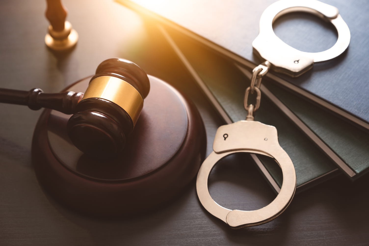Handcuffs and wooden gavel on lawyer's desk
